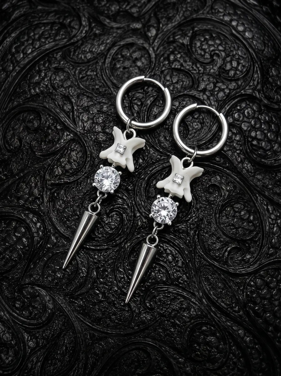 Glimmerthorn Snake Bone Earrings, pair of pale vertebrae drop earrings with silver-tone star details and pointed tips