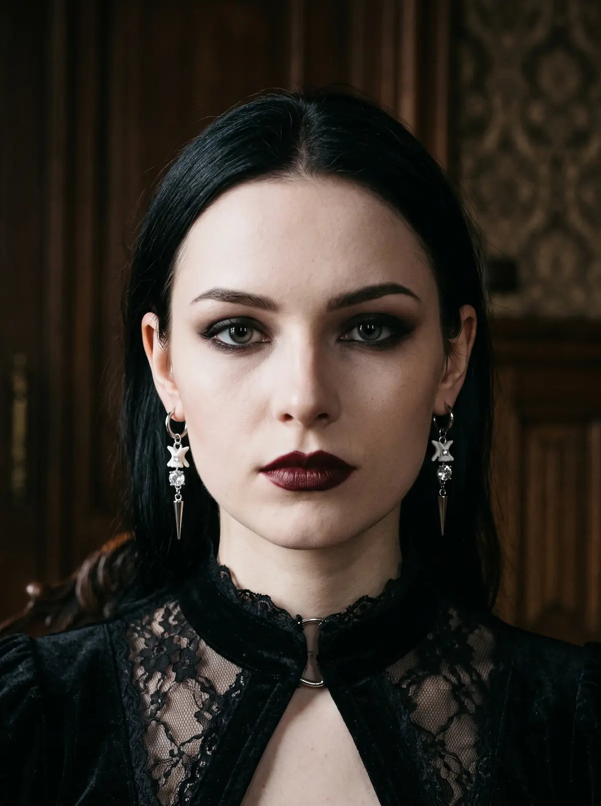 Glimmerthorn Snake Bone Earrings, front portrait with matching pale bone and silver spike earrings against black lace