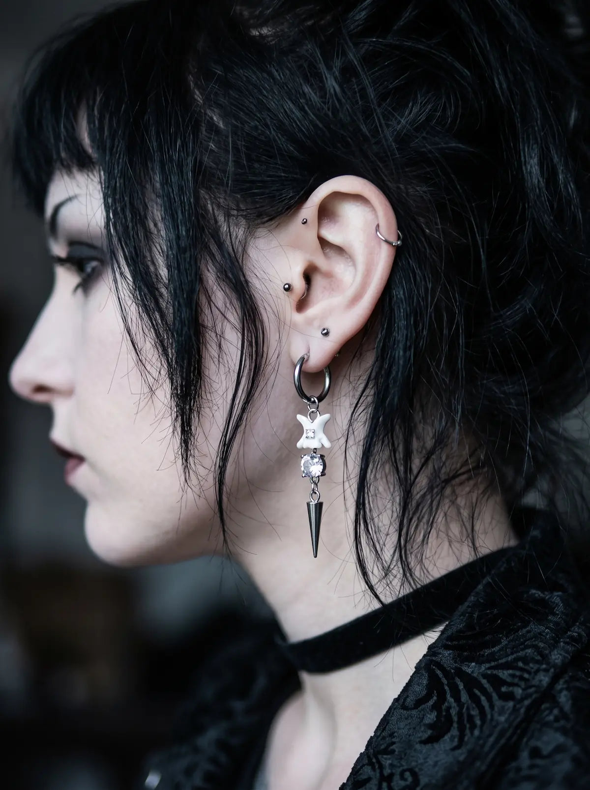 Glimmerthorn Snake Bone Earrings, side portrait displaying dangling vertebrae earring and silver-tone point