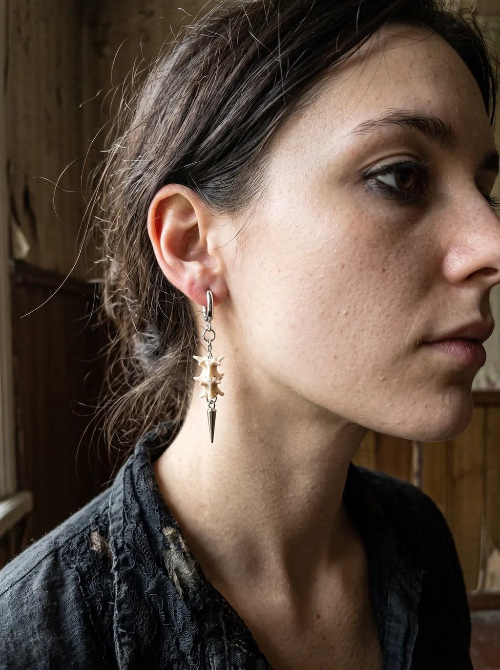 Close-up side view of a Gravechain Spike snake bone earring with chain links and a silver-tone spike