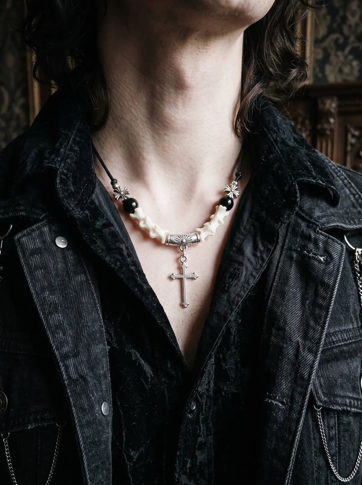 Gravecross Snake Bone Necklace, close collarbone view of white vertebrae and cross pendant under a black jacket