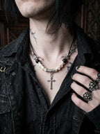 Gravecross Snake Bone Necklace, pale vertebrae necklace with black beads and silver cross on a tattooed model