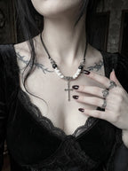 Gravecross Snake Bone Necklace, silver cross and curved snake bone necklace against a black lace neckline