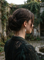 Rear three-quarter view of a Gravefeather snake bone earring worn with the hair pinned up