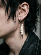Gravefork Snake Bone Earrings, side view of vertebrae earring with long silver-tone pointed drop