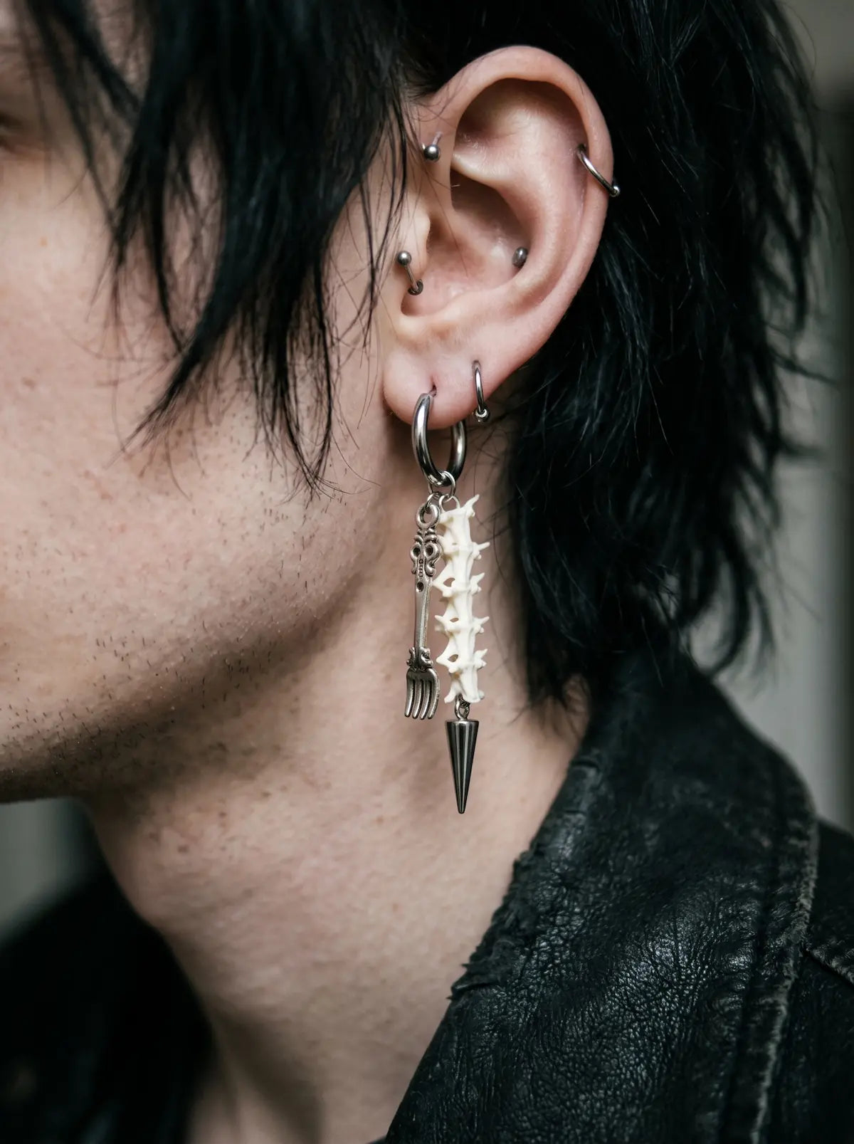 Gravefork Snake Bone Earrings, side view of vertebrae earring with long silver-tone pointed drop