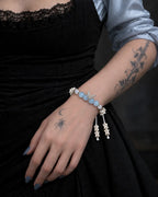 Icewing snake bone bracelet worn against a black dress with light blue sleeves, showing two dangling bone tips