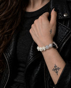 Ivory Thorn Rose snake bone bracelet worn with the hand holding a black leather jacket lapel