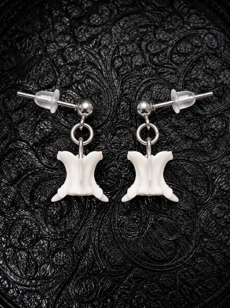 Ivory Vertebra Drop snake bone earrings with silver-tone stud posts and clear backs on black patterned fabric