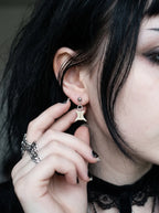 Close-up of an Ivory Vertebra Drop snake bone stud earring beside a ringed hand