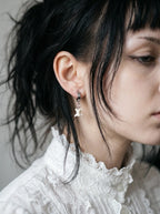 Ivory Vertebra Drop snake bone clip-on earring shown in profile above a white lace collar