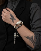 Ivory Serpent Head snake bone bracelet worn in two rows with the hand against a black vest