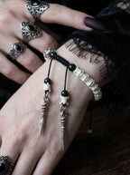 Jadefang Snake Bone Bracelet, close view of snake bone bracelet with green beads and twin pointed metal pendants