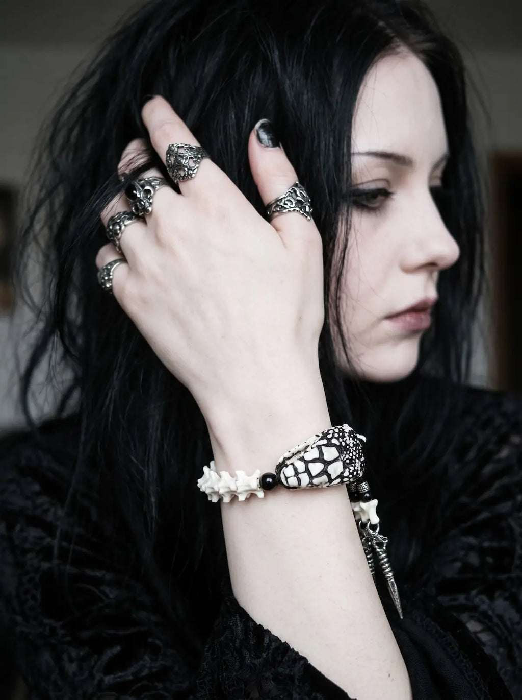 Kingshade Snake Bone Bracelet, snake head bracelet on the wrist as the model adjusts dark hair