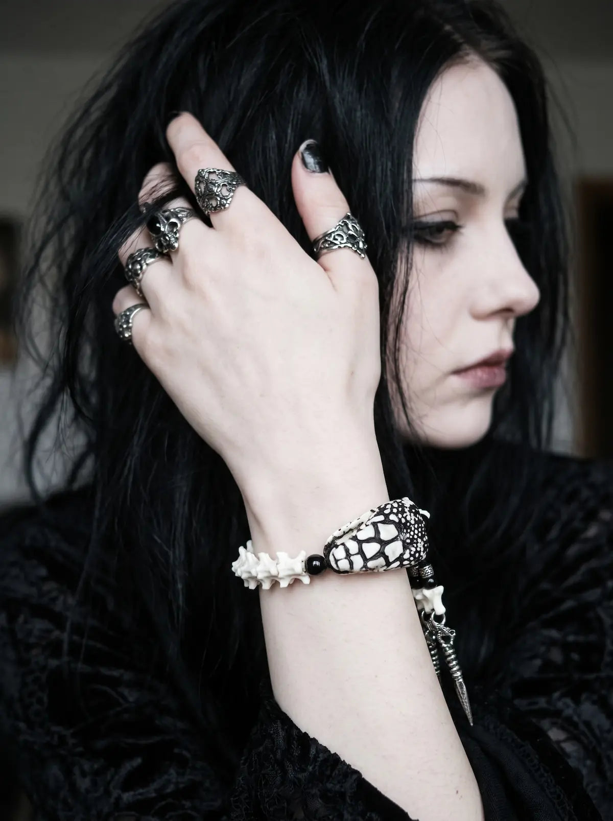 Kingshade Snake Bone Bracelet, snake head bracelet on the wrist as the model adjusts dark hair