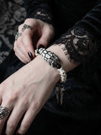 Kingshade Snake Bone Bracelet, snake head and vertebrae bracelet in close view beside black lace and silver rings