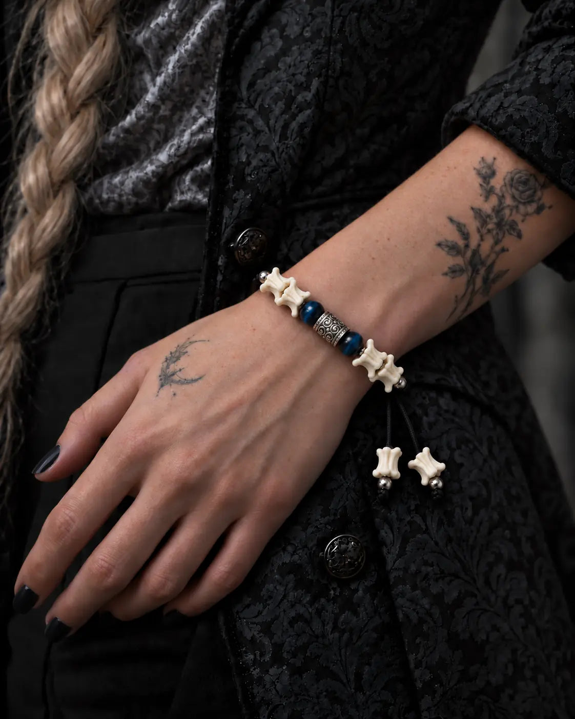 Midnight Blue snake bone bracelet worn on a wrist against a black patterned jacket