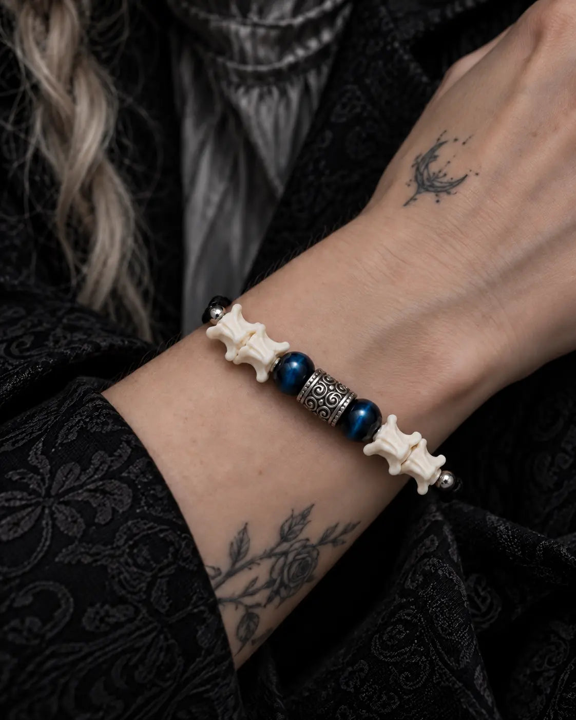 Close-up of the Midnight Blue snake bone bracelet showing its blue beads and engraved metal centerpiece