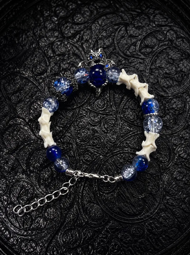 Midnight Guardian snake bone bracelet with blue and clear beads, an ornate blue centerpiece and a silver-tone clasp