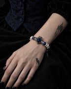Midnight Guardian snake bone bracelet on a hand resting against black velvet