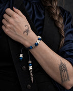 Midnight Relic snake bone bracelet worn against a black vest with blue satin sleeves