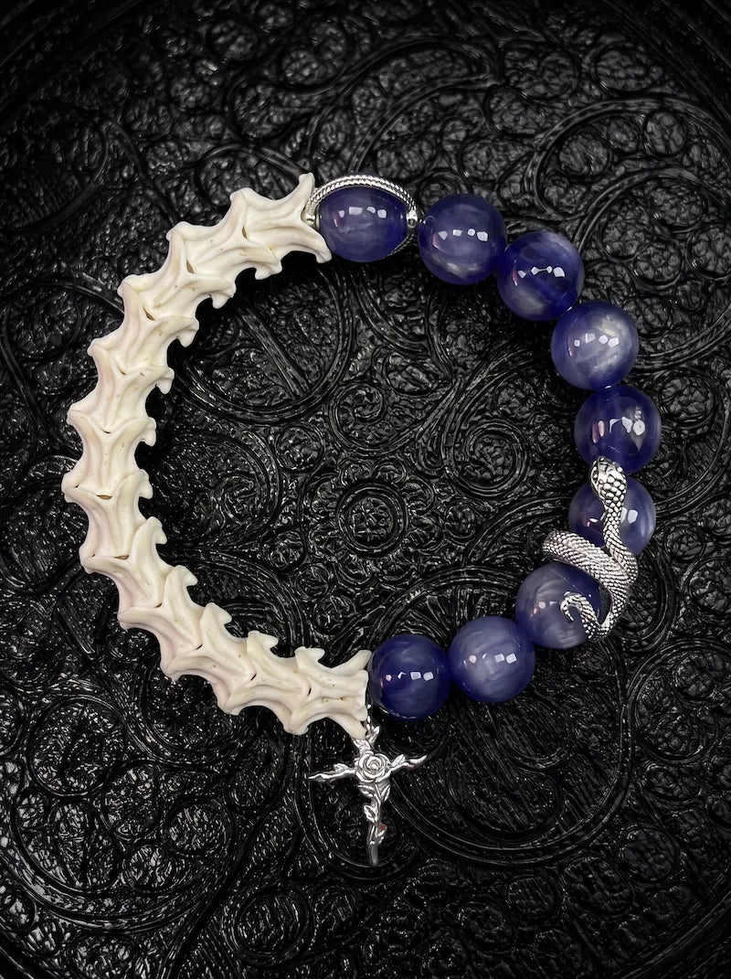 Midnight Serpent Cross snake bone bracelet with deep blue beads, a silver-tone serpent and an ornate rose cross charm