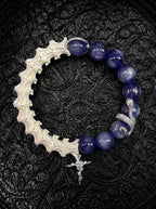 Midnight Serpent Cross snake bone bracelet with deep blue beads, a silver-tone serpent and an ornate rose cross charm