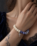 Midnight Serpent Cross snake bone bracelet worn with the hand near the neck above a black lace neckline