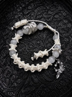 Moon Serpent snake bone bracelet with pale gray beads, a silver-tone serpent, an ornate crescent charm and white cords