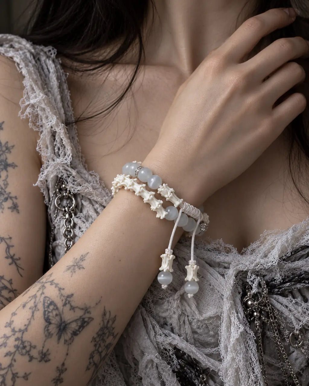 Moonveil snake bone bracelet worn in two rows with the hand resting near the neck