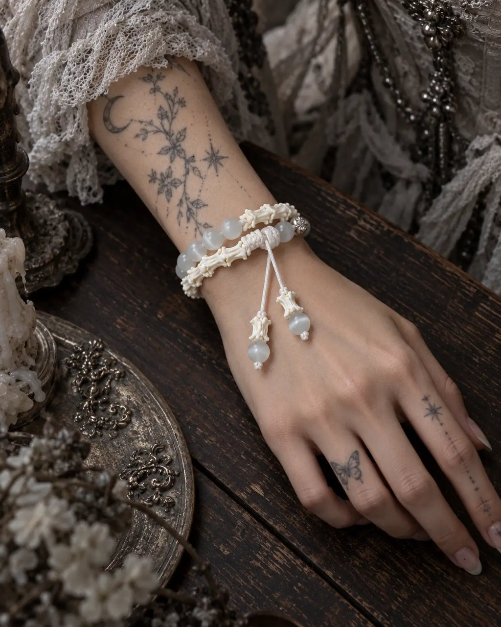 Top view of the Moonveil snake bone bracelet on a wrist resting on a dark wooden table