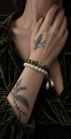 Mosswood snake bone bracelet worn in two rows with the hand resting near the neck