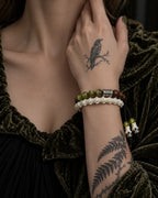 Mosswood snake bone bracelet shown beside the collarbone, with its bead row above the white vertebrae