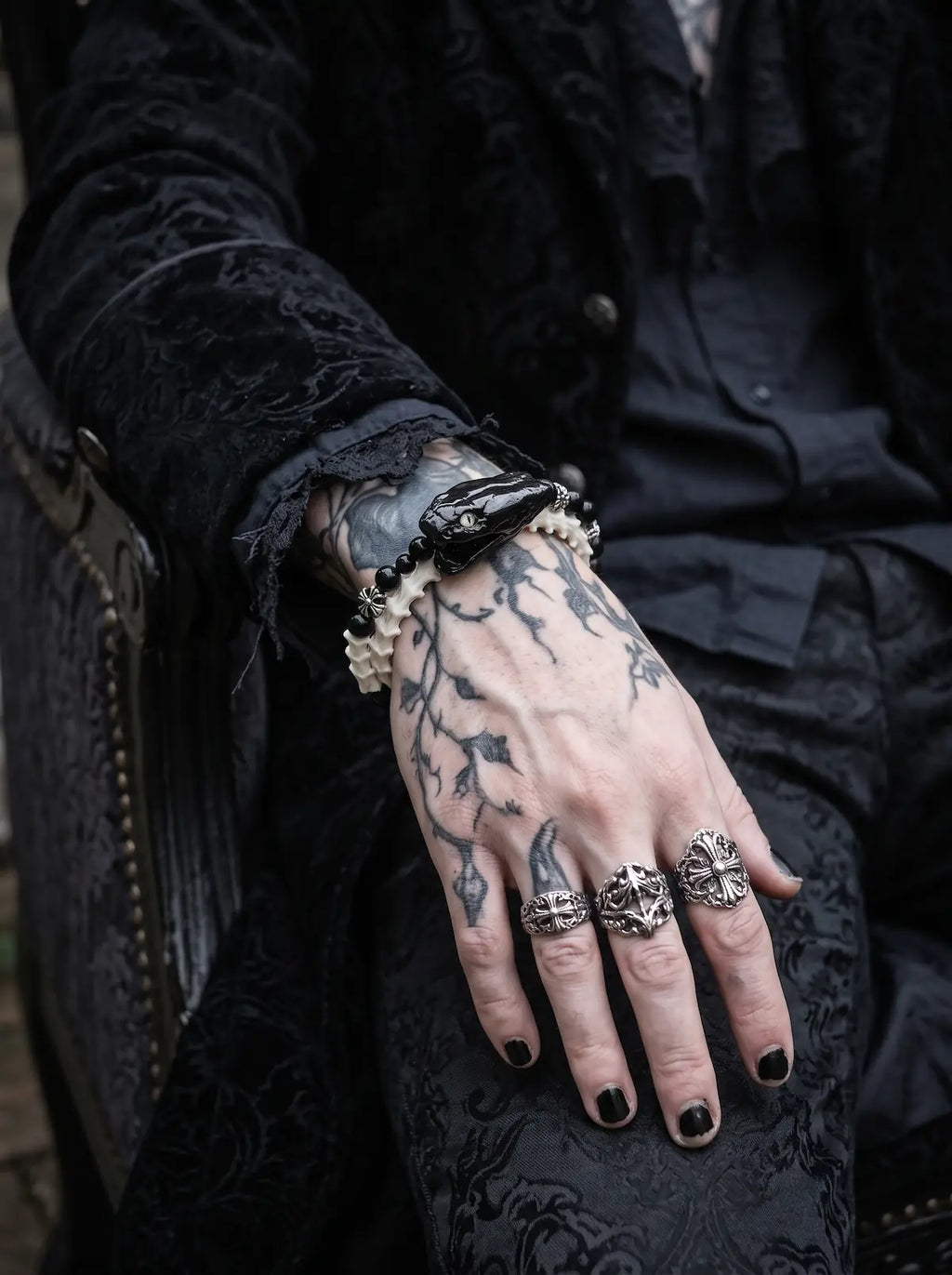 Nightreign Snake Bone Bracelet, white bone and dark snake head bracelet over a tattooed hand in black clothing
