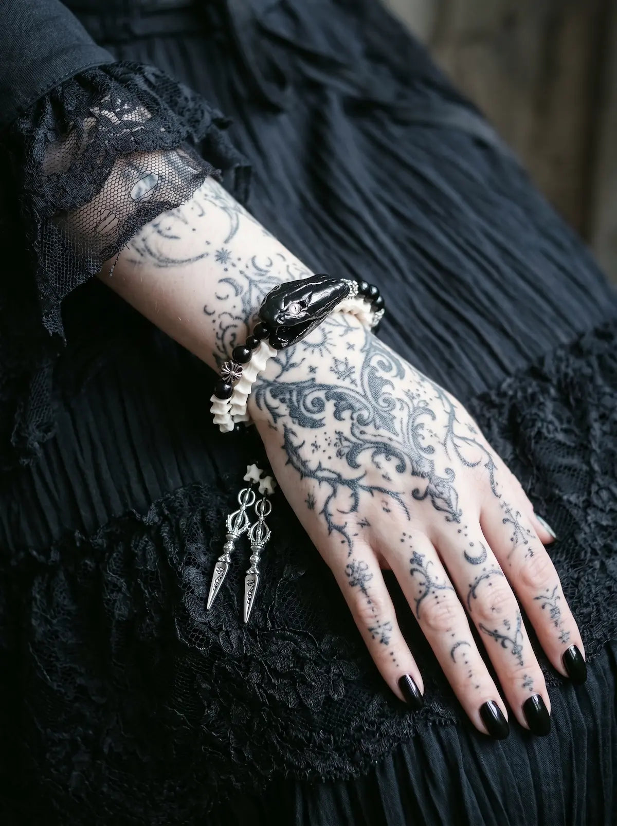 Nightreign Snake Bone Bracelet, close wrist view of preserved dark snake head and white vertebrae with pendants