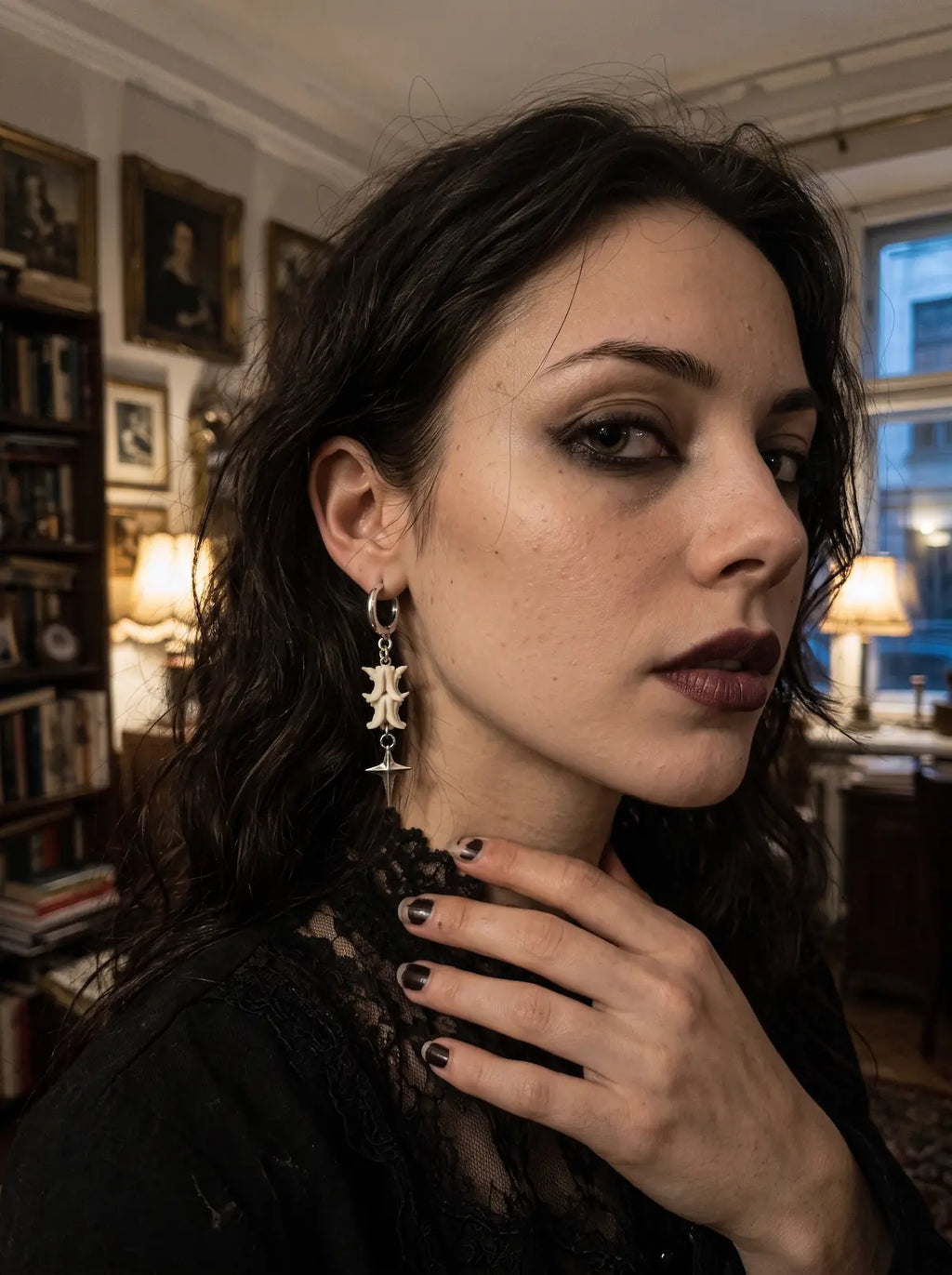 Nightstar snake bone earring shown in three-quarter profile above a black lace collar