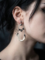 Nocturne Arc Snake Bone Earrings, curved vertebrae hoop earring worn at the ear with small dark bead accents