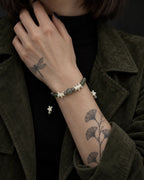 Olive Bead snake bone bracelet shown on a raised wrist with the hand at the neck