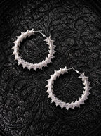 Ossuary Hoop snake bone earrings arranged diagonally as a pair on black patterned fabric