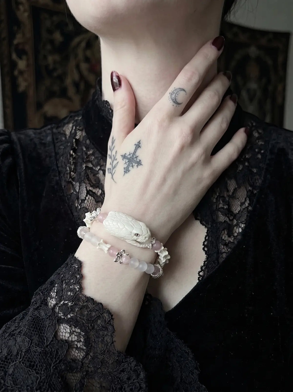Petalshade Snake Bone Bracelet, pink bead and pale snake bone bracelet worn on a wrist near the collarbone