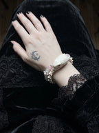 Petalshade Snake Bone Bracelet, snake head bracelet worn on a hand lifting dark hair, showing its double-row look