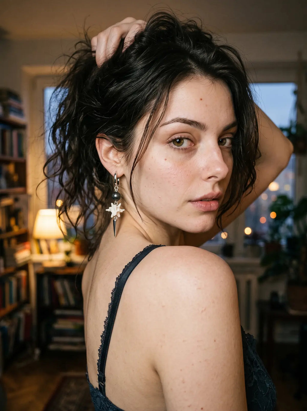 Black-bead Prismatic Fang snake bone earring worn with the hair lifted in a rear three-quarter portrait