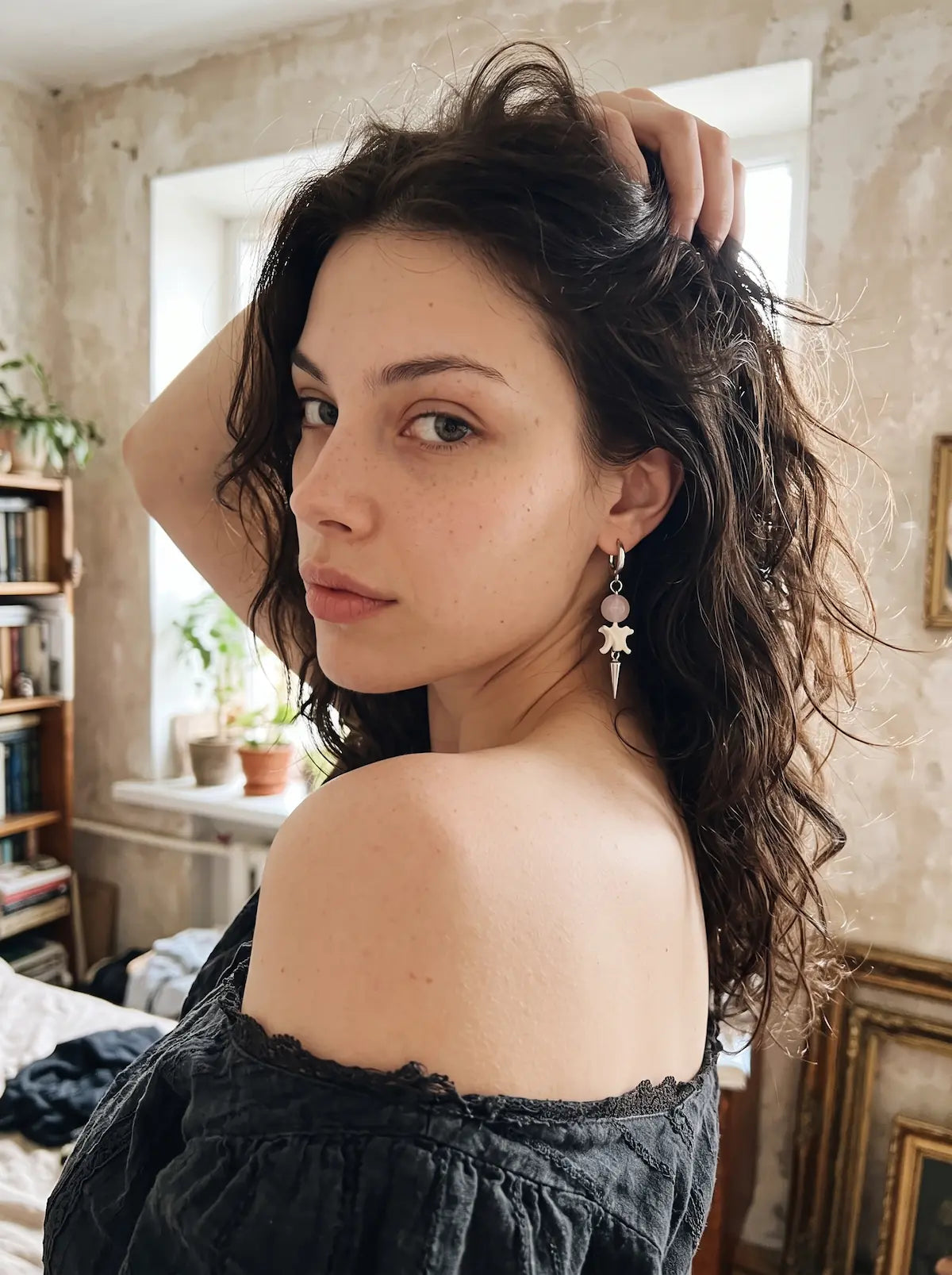 Prismatic Fang snake bone earring with a dark bead, shown over the shoulder with the hair held up