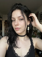 Pale green Prismatic Fang snake bone earring worn above a black lace neckline and choker