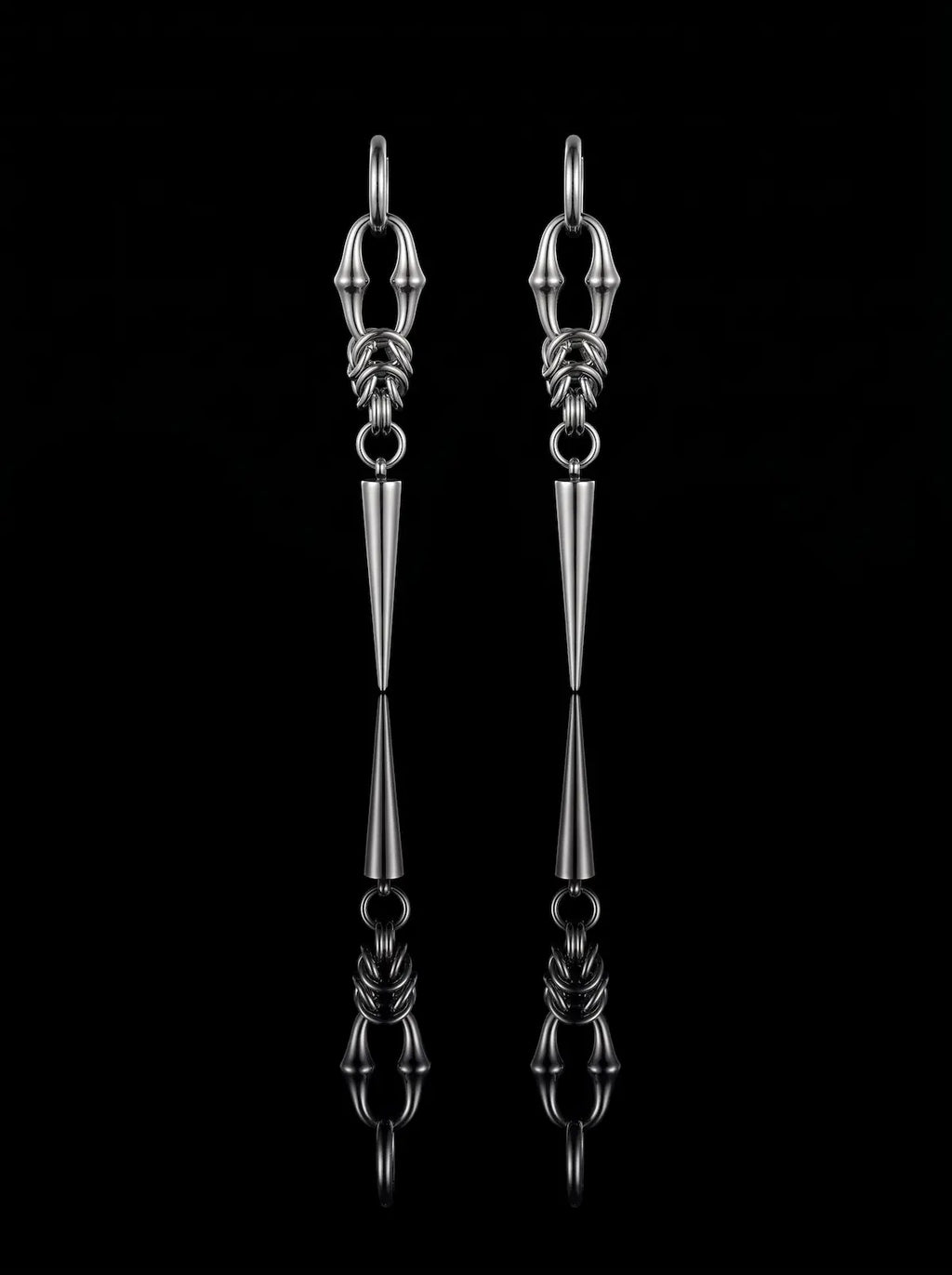 Pair of silver Razor Fang Spike Earrings with long tapered spike pendants on a black background