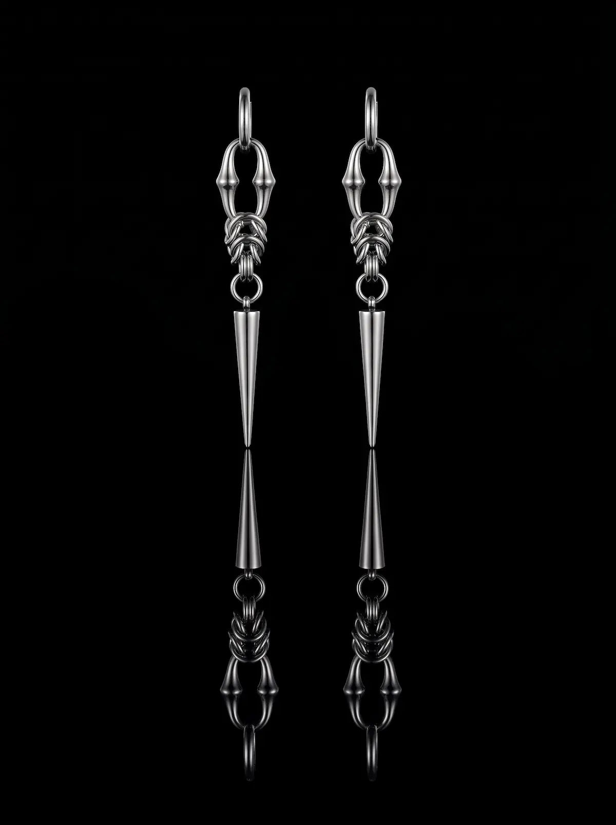 Pair of silver Razor Fang Spike Earrings with long tapered spike pendants on a black background