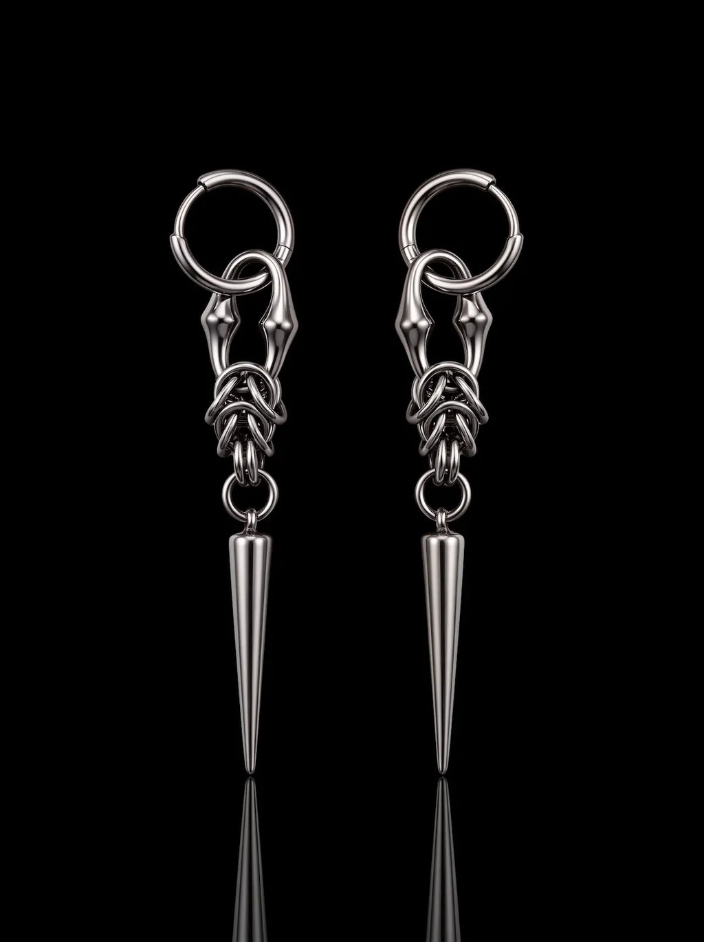 Pair of Razor Fang Spike Earrings with silver hoops and long pointed spike pendants on a black background