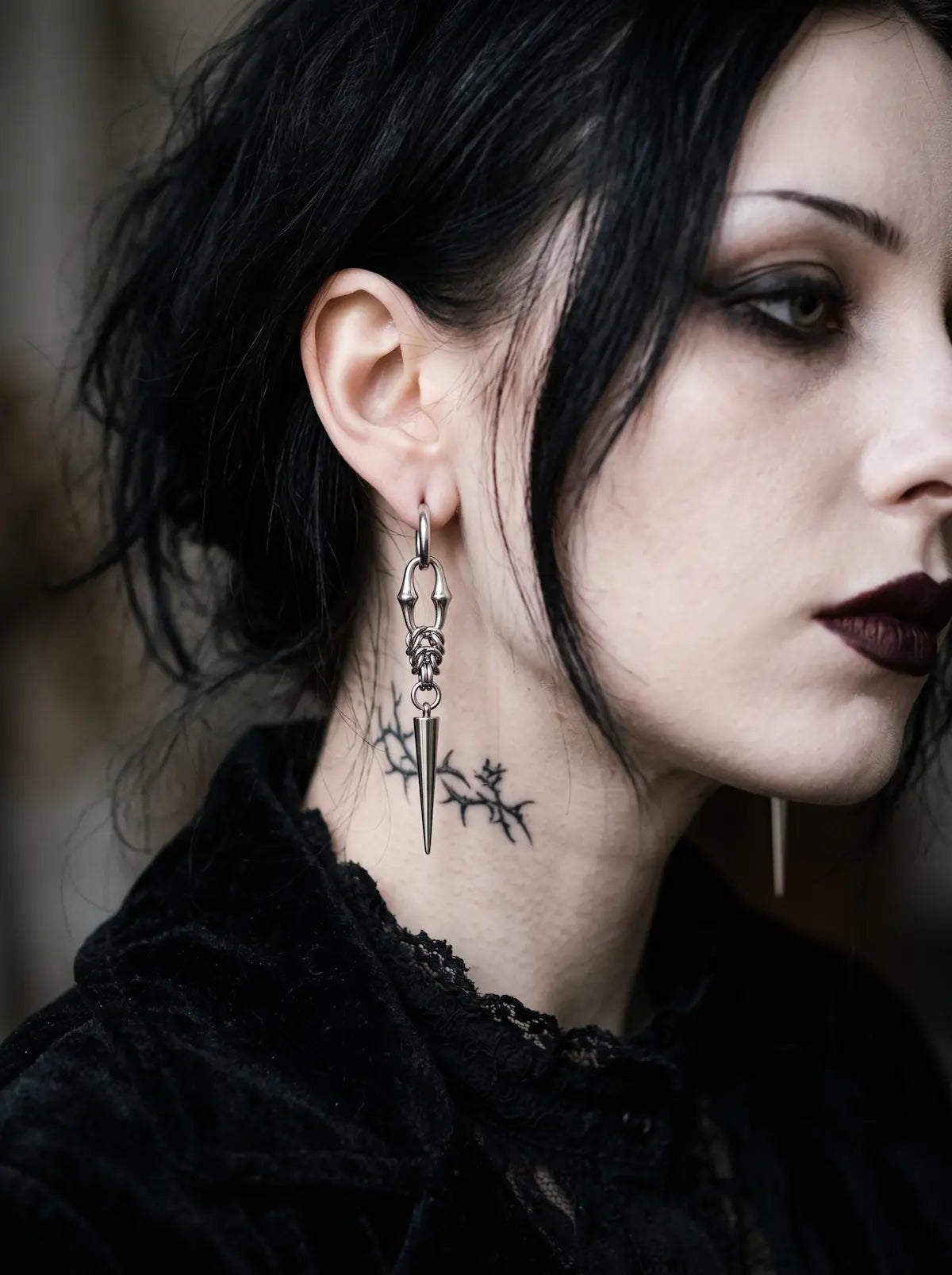 Gothic woman with black hair wearing Razor Fang Spike Earrings and dark makeup