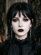 Gothic woman wearing a pair of Razor Fang Spike Earrings with long silver spike pendants