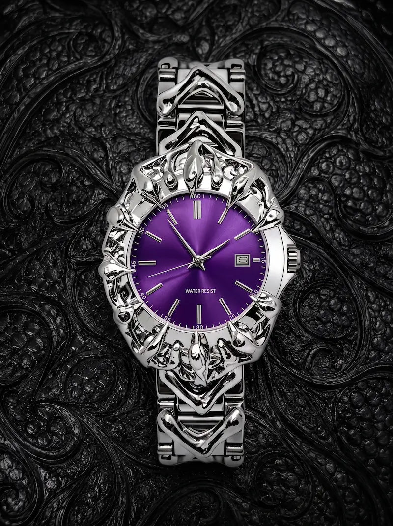 Razorclaw Gothic Watch, purple dial and sculpted silver-tone claw case, flat lay on patterned black fabric